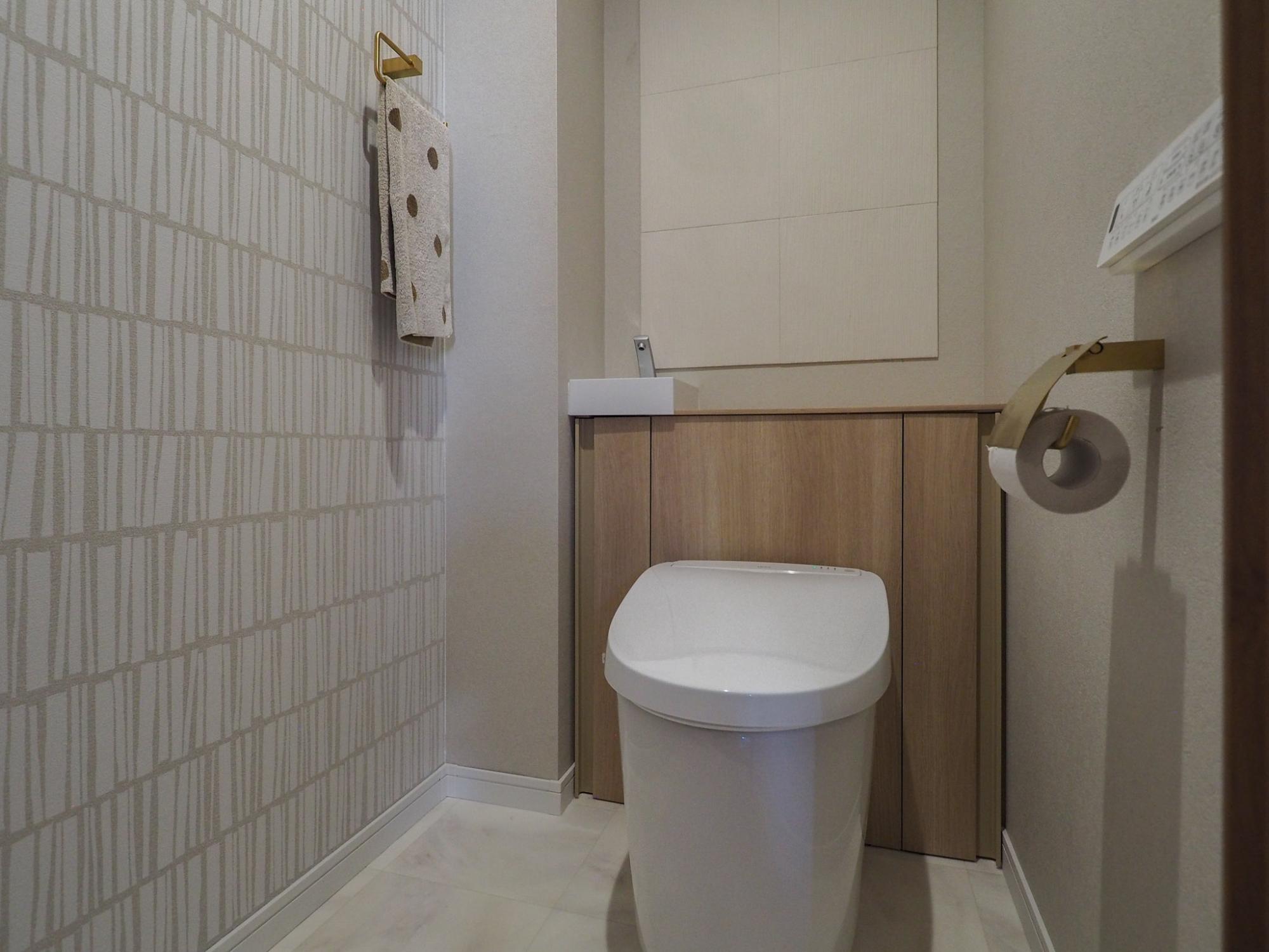 タンクレスのトイレに取り換えました。給水管やコードはキャビネット内で見た目はすっきり。お掃除もらくらくなアクアセラミックの衛生陶器です。