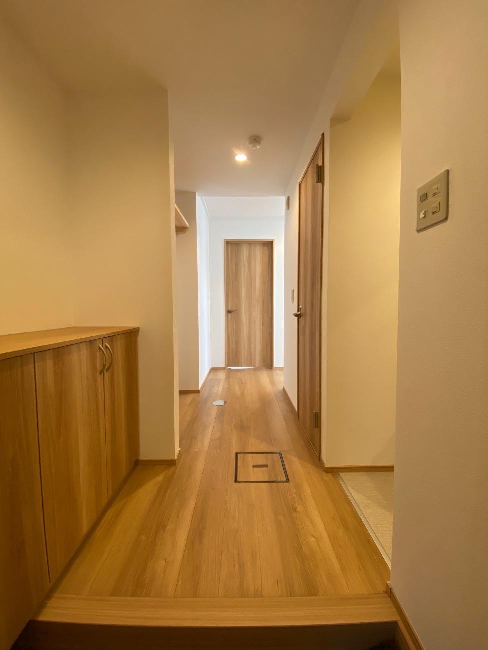 玄関を開けてすぐに住空間が見えないような工夫をし、これまでなかった下駄箱も確保。