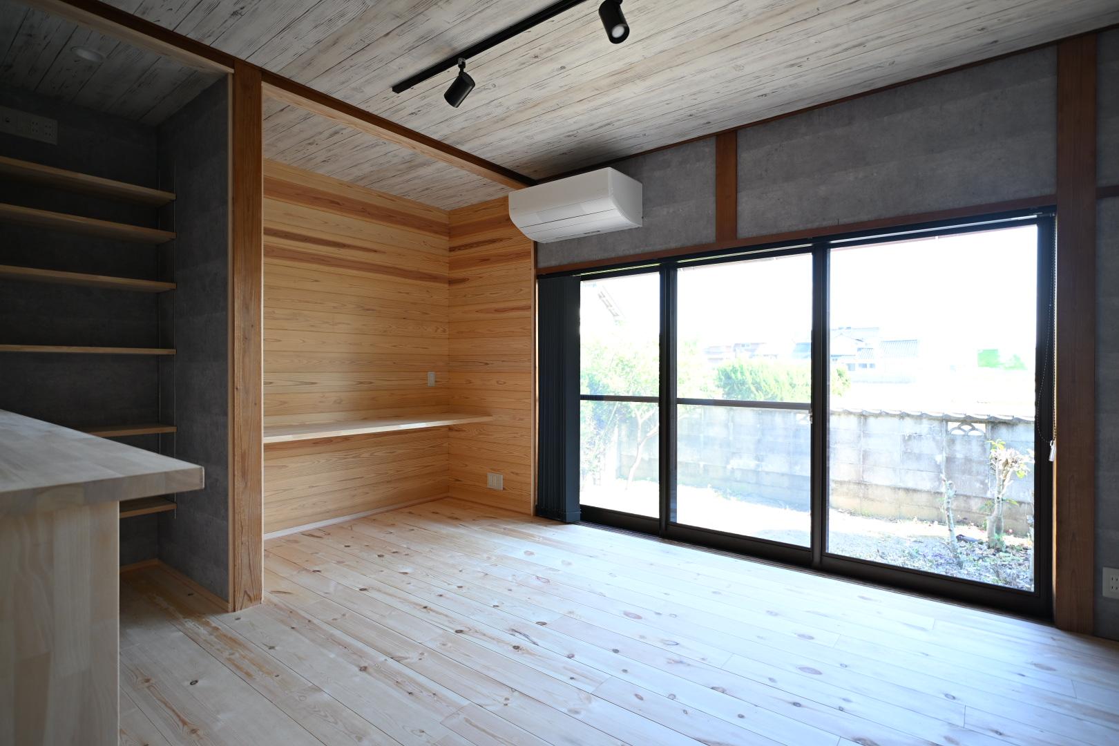手前はキッチン、奥はご主人がゲームを満喫する専用空間です。元は布団箪笥だった押し入れの建具を取り払い、パソコン等の機器を置くPCスペースへと刷新しました。大きな引き違い窓からは明るい光がたっぷりと差し込み、庭の家庭菜園やのどかな田園風景を眺めながら、心ゆくまで趣味の時間を楽しむことができます。